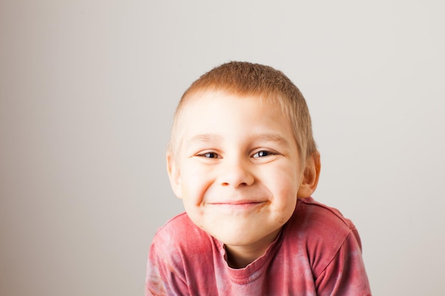 Portrait of fair-haired funny boy with chocolate on his face