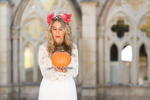 Portrait of a fairy tale queen holding a pumpkin