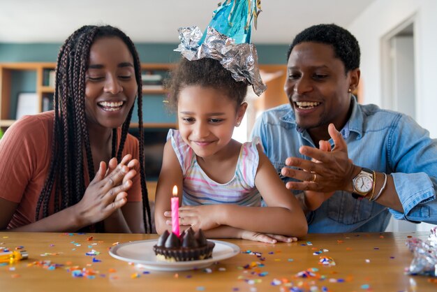 Portrait of a family celebrating birthday online on a video call while staying at home.