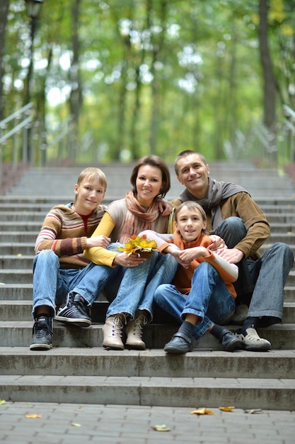 Portrait of family of four sitting in park