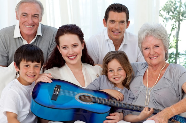 Portrait of family holding a guitar in living-room