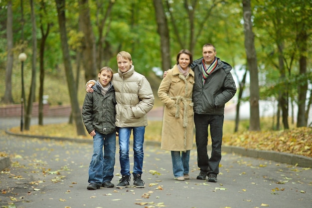 Ritratto di famiglia che si rilassa nel parco autunnale