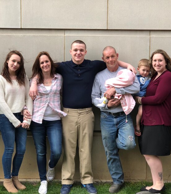 Foto ritratto di una famiglia in piedi accanto al muro