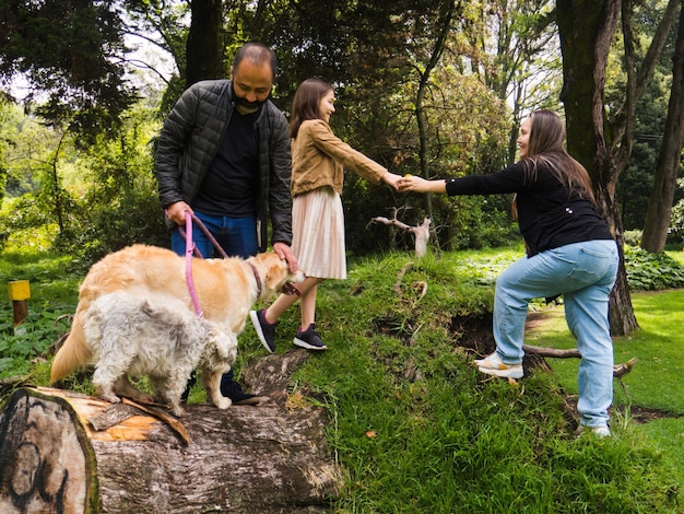 Foto ritratto di una famiglia che fa passeggiare i cani nel parco