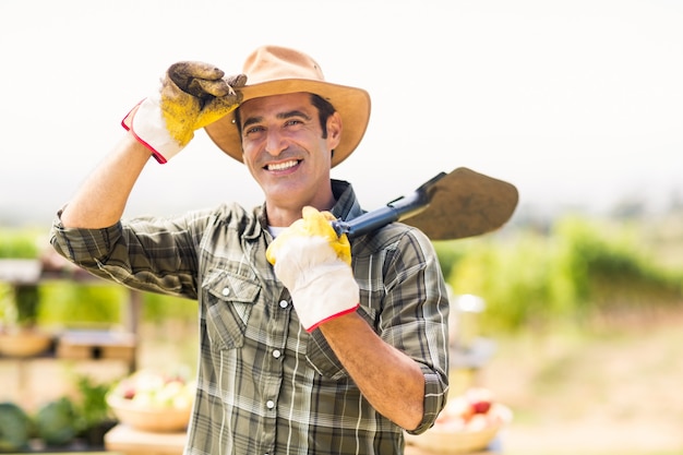 Portrait of farmer carrying shovel