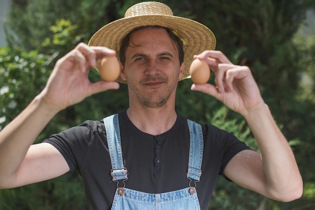Photo portrait of farmer showing eggs while standing outdoors
