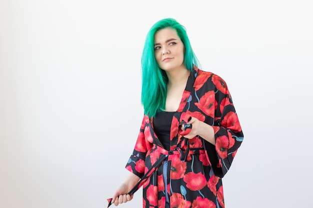 Portrait, fashion and hair coloring concept - young woman with green hair dressed kimono over the white background with copy space.