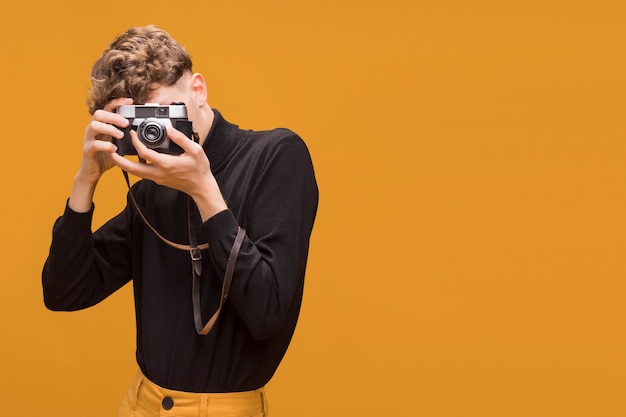 Portrait of fashionable boy taking a photo