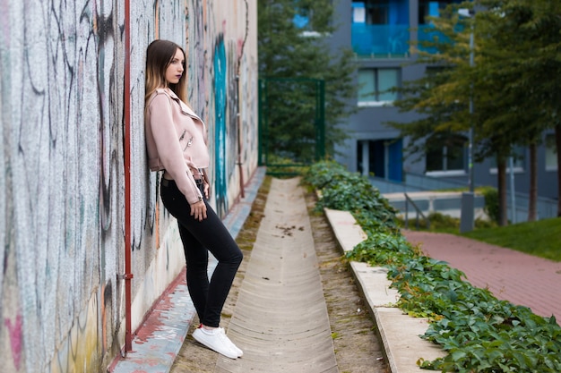 Portrait of fashionable girl on graffiti wall