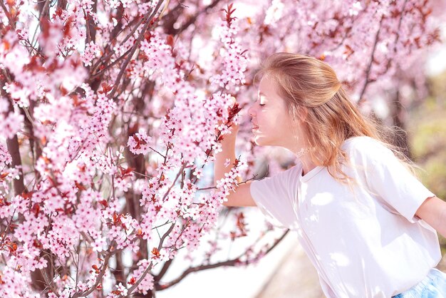 Photo portrait of a fashionable little girl near flowering trees