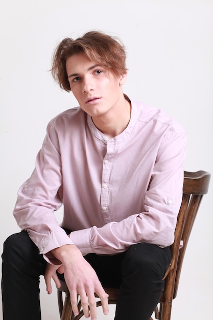 白い背景に座っているファッショナブルな男の肖像画