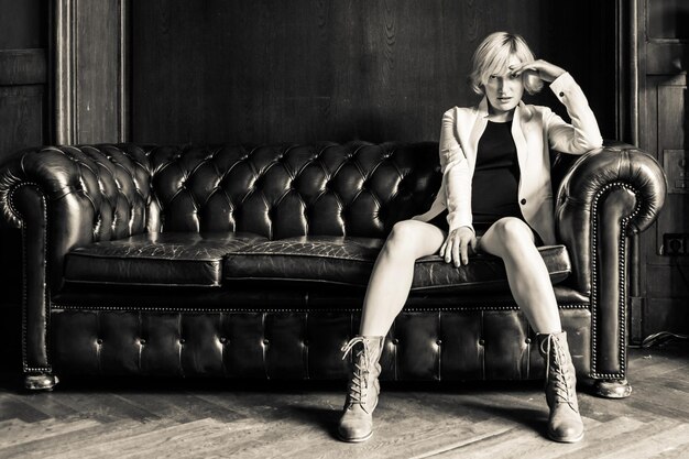 Photo portrait of fashionable woman sitting on sofa at home