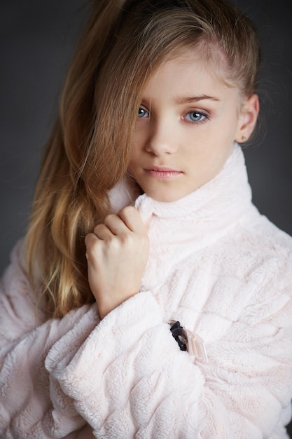 Portrait of fashionable young girl in white coat with long hair