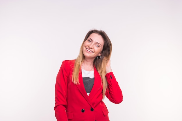 Portrait of fashionable young white freckled woman in red suit on white background.