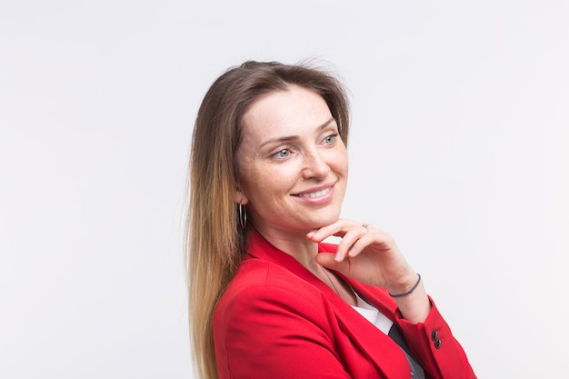 Portrait of fashionable young white woman posing in red suit in studio