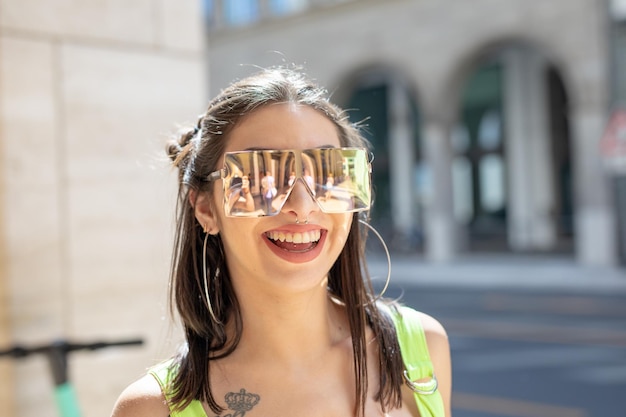 Portrait of fashionable young woman wearing sunglasses in city during sunny day