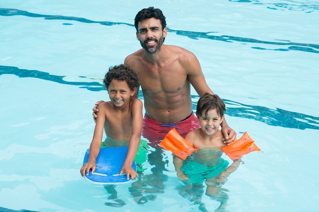 Portrait of father and kids smiling in the pool