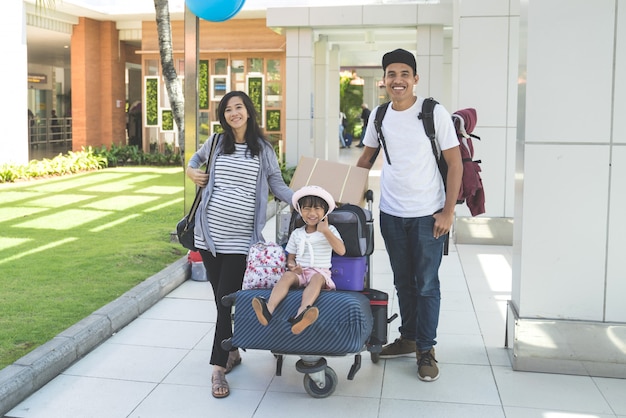 Portrait of father, mother and their daughter standing and smiling look at camera