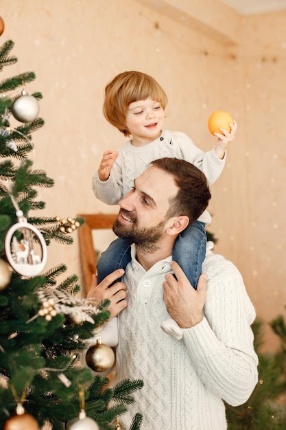 家でクリスマス ツリーを飾る父と息子の肖像画