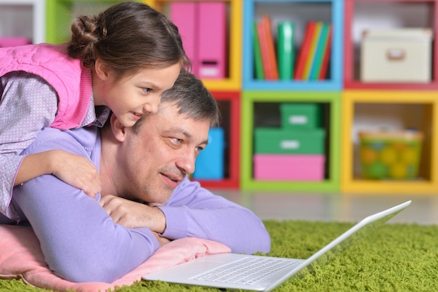 Portrait of a father with a little daughter using a laptop