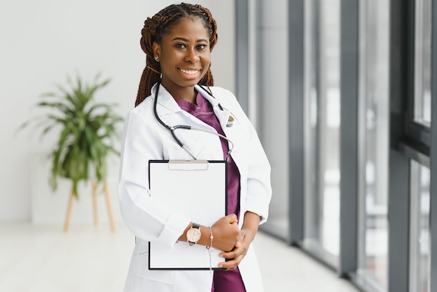 Portrait of female African American doctor standing in her office at clinic