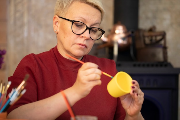 Ritratto di artista femminile dipinto su pentola di terracotta gialla in studio d'arte domestica