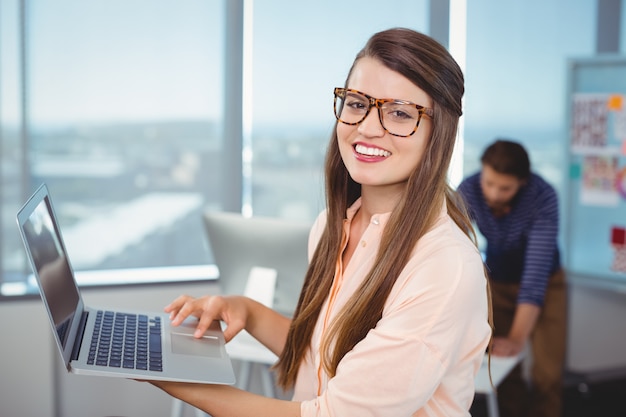 Portrait of female business executive using laptop