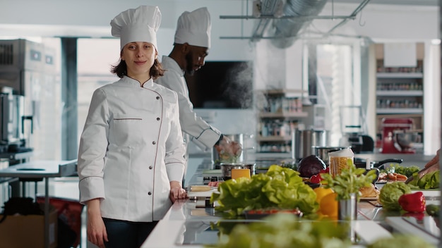 Foto ritratto di chef femminile con uniforme che lavora nella cucina del ristorante