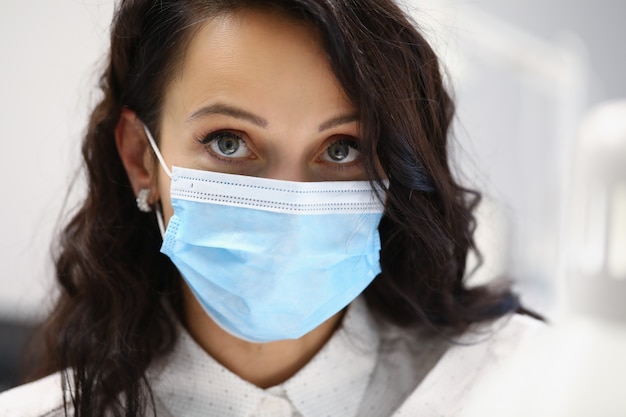 Portrait of female client wearing protective face mask. Prevention virus spread. Brunette