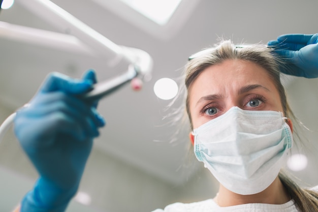 Portrait of female dentist . She examining a patient's teeth .