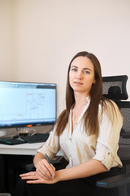 Portrait female designer estimator sitting table with a notebook and calculator counting the balance