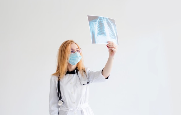 Портрет женщины-врача, смотрящей на рентген грудной клетки