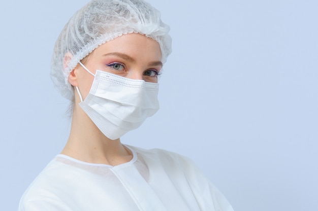 의료 모자와 얼굴 마스크를 착용하는 여성 의사 또는 간호사의 초상화