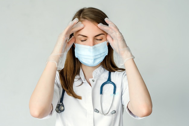 Portrait of female doctor suffering from headache in clinic