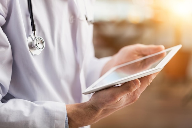 Portrait of female doctor using her digital tablet in the office.