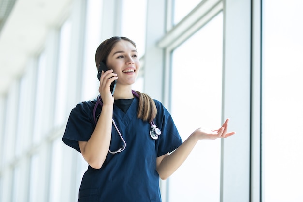 Ritratto di una dottoressa che utilizza il telefono cellulare nel suo ufficio ospedaliero