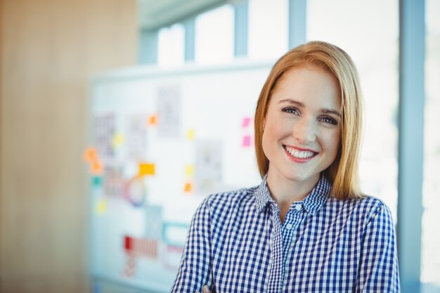 Portrait of female executive standing in conference room