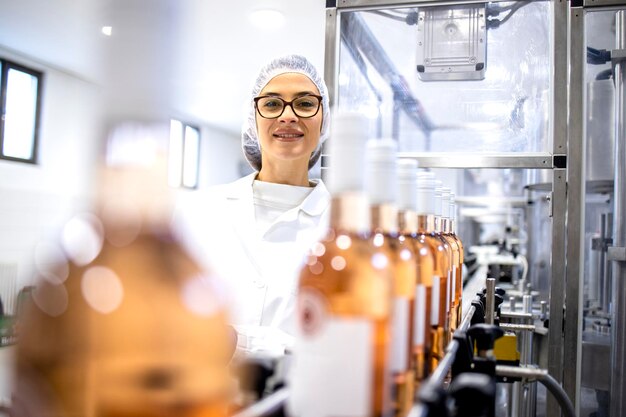 Portrait of female factory supervisor controlling wine production in alcohol beverage bottling plant