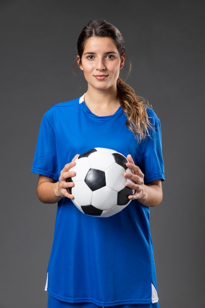 portrait female football player with ball