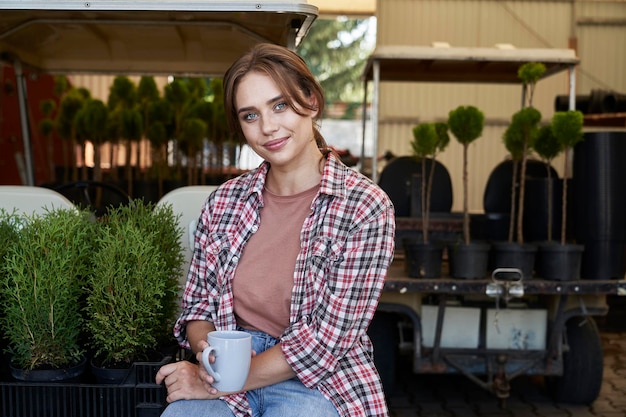 Portrait of female greenhouse plantation worker holding a cup of tea