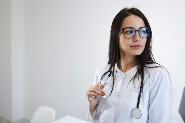 Portrait of female medic with stethoscope. Beautiful young nurse with glasses