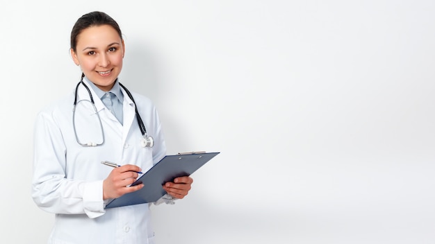 Portrait of a female medical worker. Young doctor with clipboard on white. for copyspace