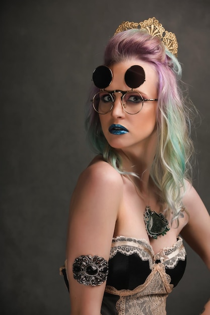 Portrait of female model in the crown with colorful makeup and sunglasses Fashionable hair coloring Fashion trends