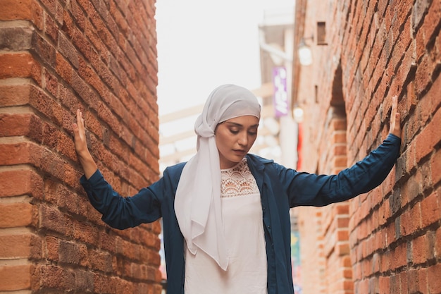 Ritratto di modello femminile in stile hijab alla moda in posa su sfondo urbano elegante donna musulmana