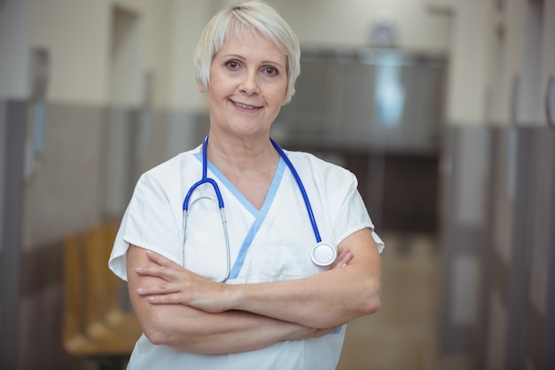 Portrait of female nurse standing in corridor