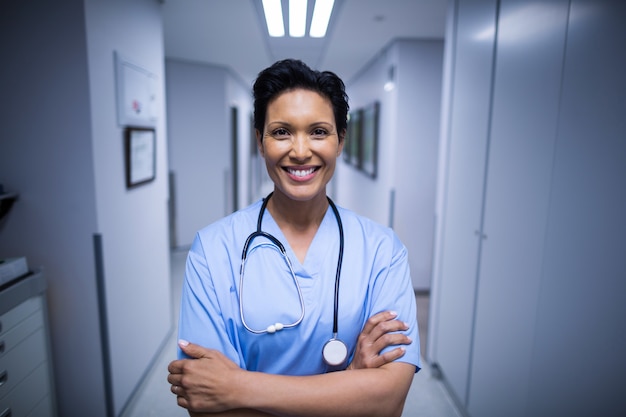 Portrait of female nurse standing in corridor