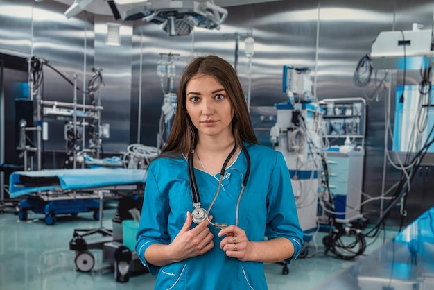 Portrait of female nurse in white uniform and stethoscope in operating room in hospital