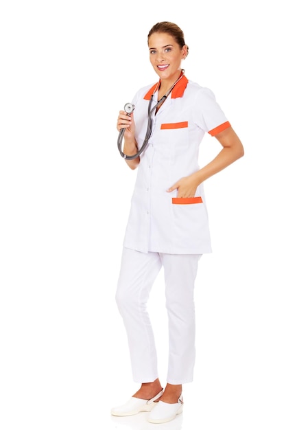 Portrait of female nurse with stethoscope standing against white background