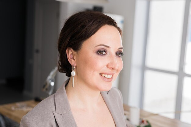 Portrait of a female online store business owner looking away and smiling woman doing her small