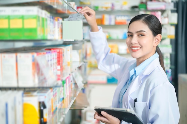 Portrait of female pharmacist using tablet in a modern pharmacy drugstore